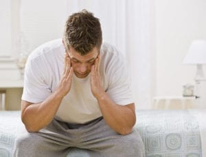 tired man sitting on bed