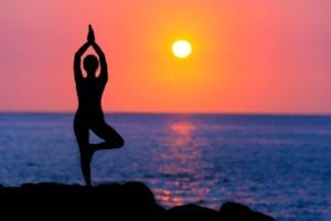 woman doing yoga at sunset