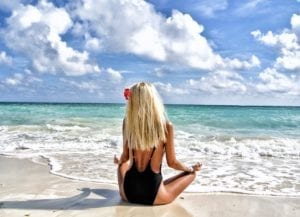 meditating blonde on beach
